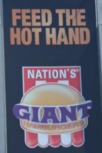 Feed the Hot Hand text above a photo of a Nation's brand Giant hamburger